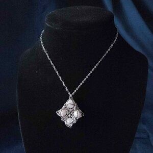 White pearl diamond-shaped pendant on a silver chain necklace